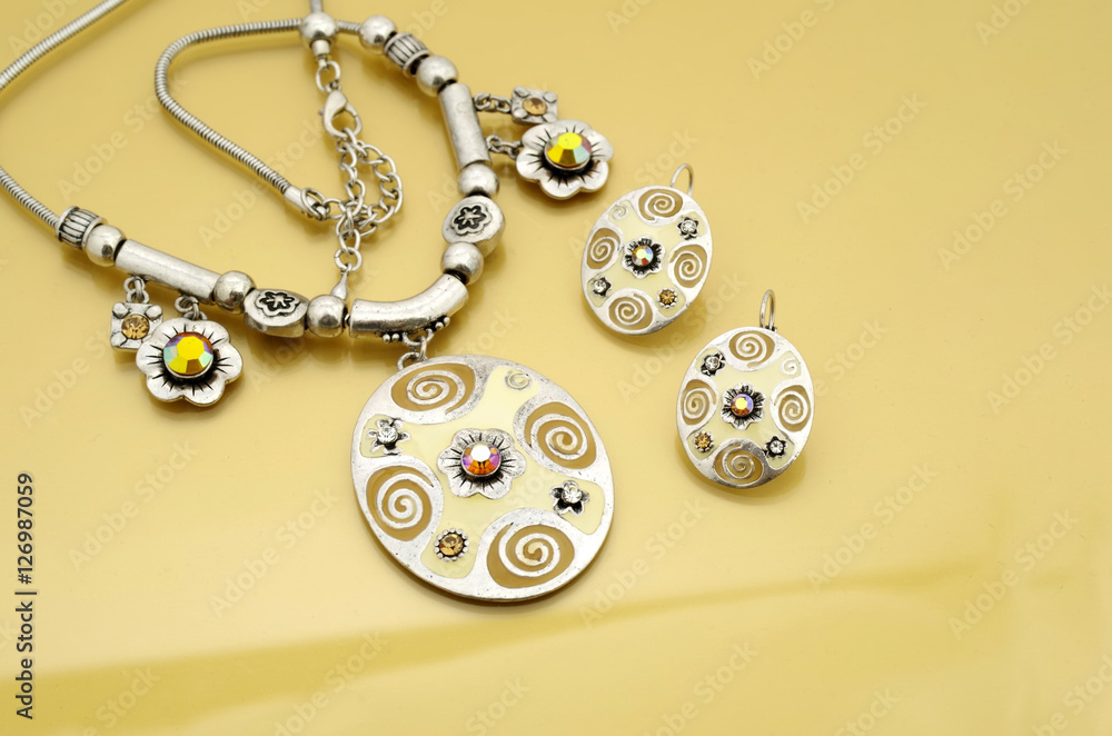Enamel oval medallion with earrings on golden background Enamel oval medallion with earrings on golden background