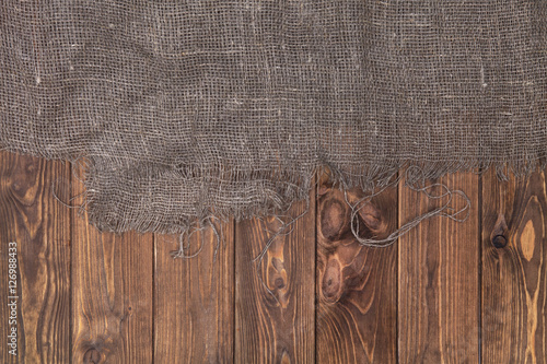 Burlap on wooden table background, top view