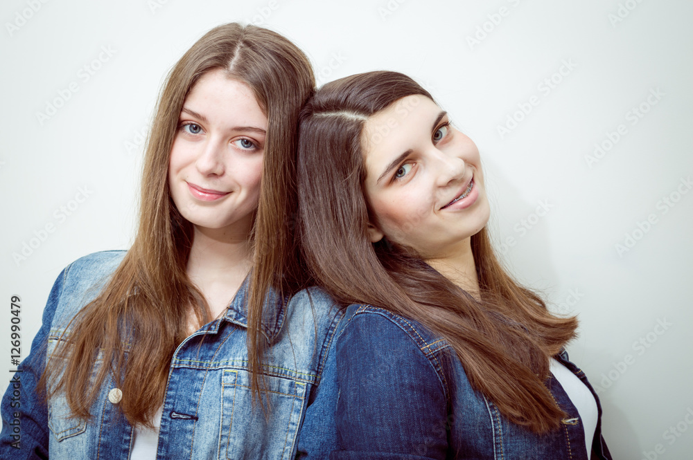 fashion photo of two beautiful young women with long dark hair and bright makeup wears casual clothes,posing in studio fashion photo of two beautiful young women with long dark hair and bright makeup wears casual clothes,posing in studio