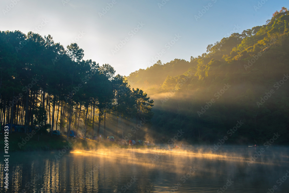 Fototapeta premium Morning in Pang Ung Lake,North of Thailand, is a tourist place where people come to vacation in the winter. Because of the large reservoir The cold causes steam to rise above the surface.