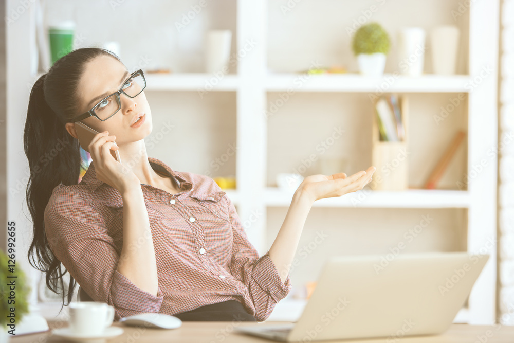 Lady talking on phone at workplace Lady talking on phone at workplace