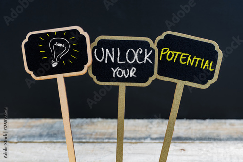 Concept message UNLOCK YOUR POTENTIAL and light bulb as symbol for idea
