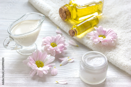 flowers in bowl and oil on wooden background