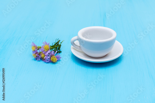 Миниатюрная чашка с кофе и двумя конфетами на столе