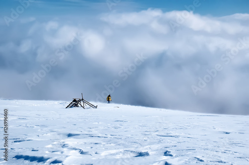 Amazing panorama sunny winter landscape with snowstorm and hiker