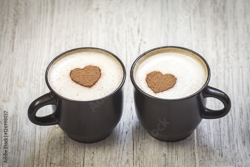 Two coffee cups with cinnamon heart shape