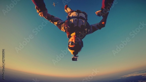 Skydiver at the sunset with plane and the moon behind