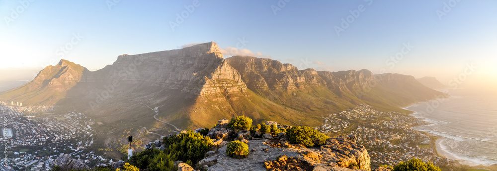 Obraz premium XXL panorama Góry Stołowej i pasma górskiego Dwunastu Apostołów widziana z Głowy Lwa w pobliżu Signal Hil w wieczornym słońcu. Camps Bay po prawej stronie, miasto Kapsztad po lewej stronie. Afryka Południowa.