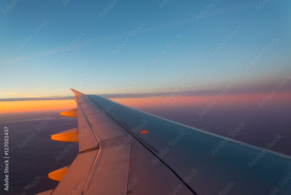 Airplane's window shot during the sunrise and cloudy sky