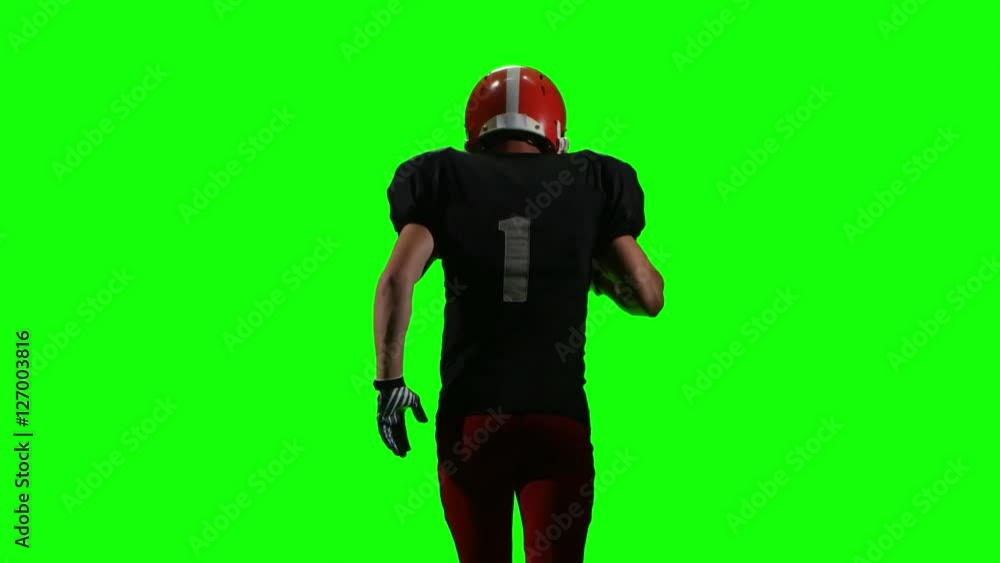 Football player running with the ball and throws it to the side. Green screen, back view Football player running with the ball and throws it to the side. Green screen, back view