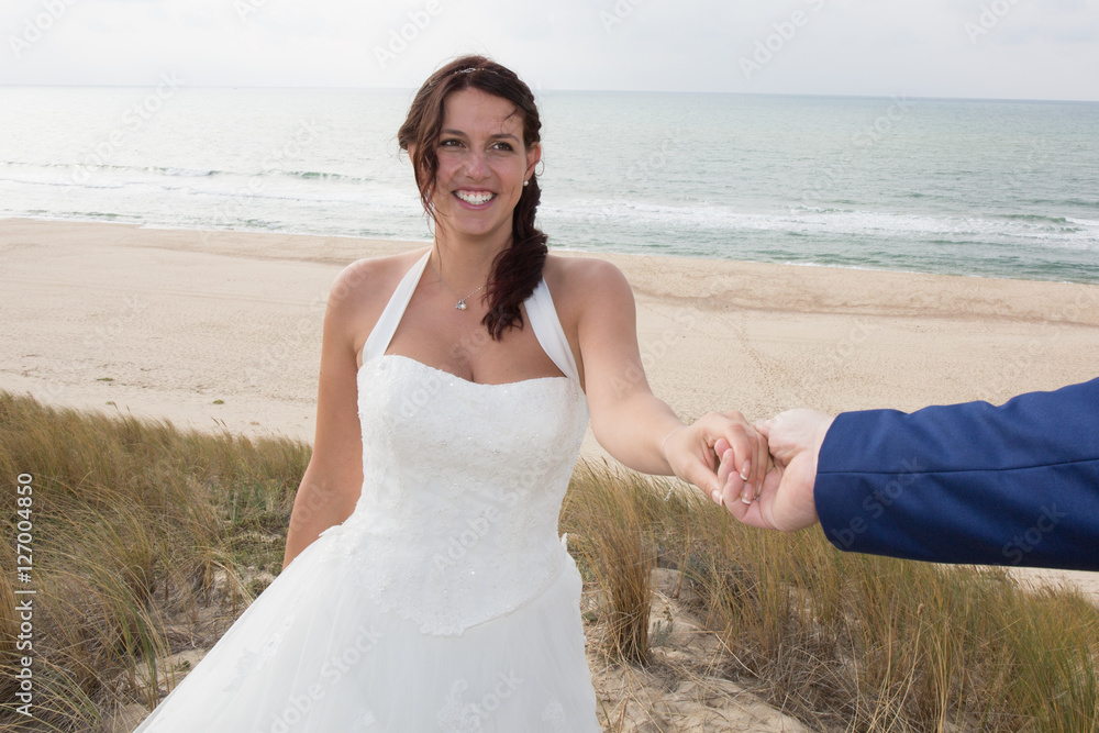 Holding Hands with wedding rings on the background of sea Holding Hands with wedding rings on the background of sea