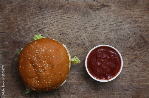 The Burger and the fresh ingredients on the old Board. On a black chalkboard. Top view. photo