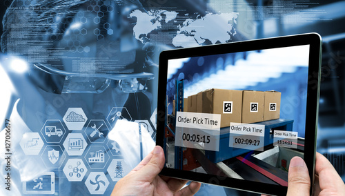 Industry 4.0,Augmented reality and smart logistic concept. Hand holding tablet with AR application for check order pick time in smart factory warehouse.Man use AR glasses and infographic background.