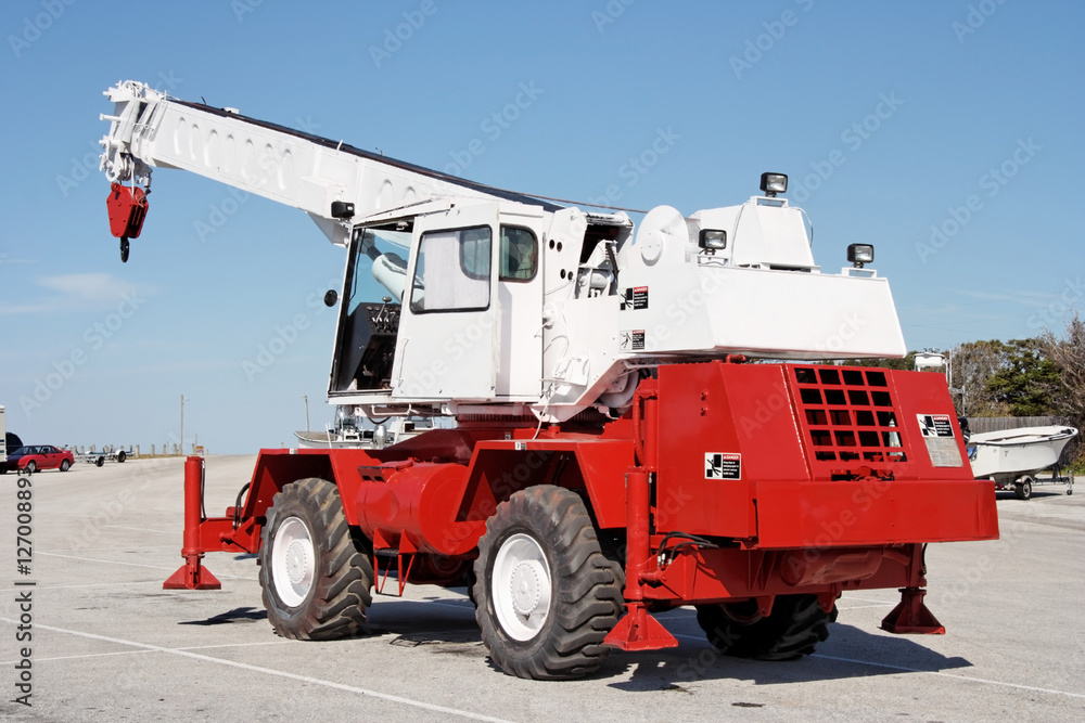Heavy-duty hook on crane truck arm  against blue sky. Vertical.
