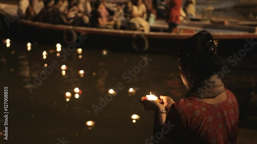 MS TU TD Woman putting offerings into Ganges river / Varanasi, India