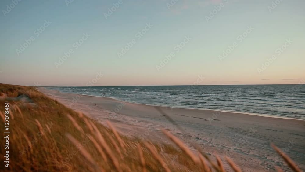 Sandy beach with words and a heart written on it and dunes covered with grass on a beautiful evening at the sea Sandy beach with words and a heart written on it and dunes covered with grass on a beautiful evening at the sea
