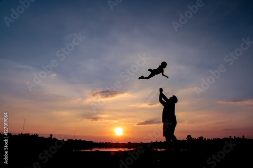 Family concept, Silhouette of father throwing son into the sky.