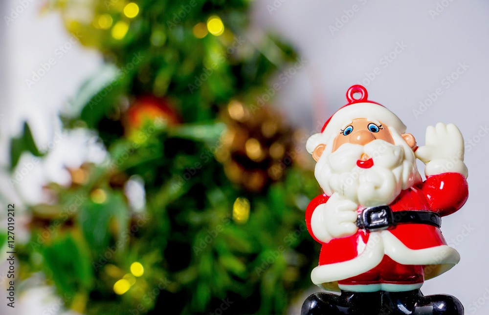 Colorful figurine of Santa Claus standing near Christmas trees