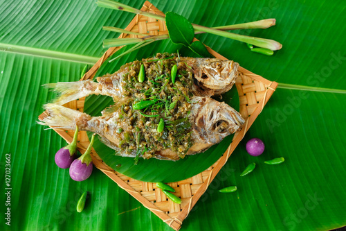 Deep fried fish with chlli sauce  on banana leaf photo