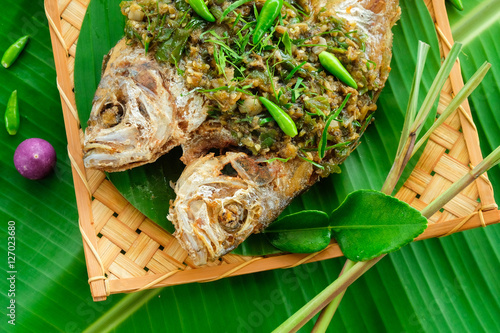 Deep fried fish with chlli sauce  on banana leaf photo