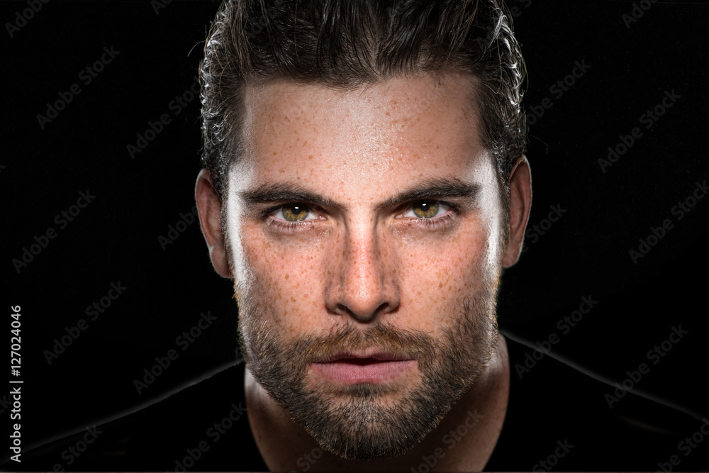 Handsome male model with masculine facial hair and intense eyes on isolated  black background Stock Photo | Adobe Stock