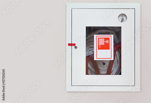 Wall mounted fire hose in an easily accessible box