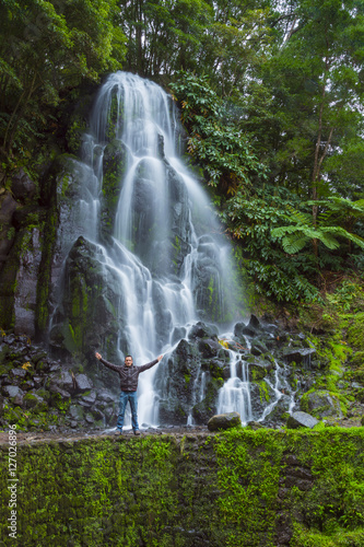 Obraz na płótnie man with open arms in front of a big waterfall w salonie