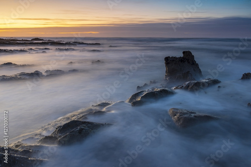 sunset at beach with rocks and waves