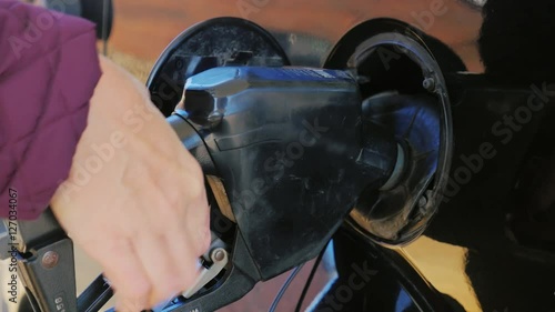 Hand with the refueling nozzle. Fill the car with petrol or diesel photo