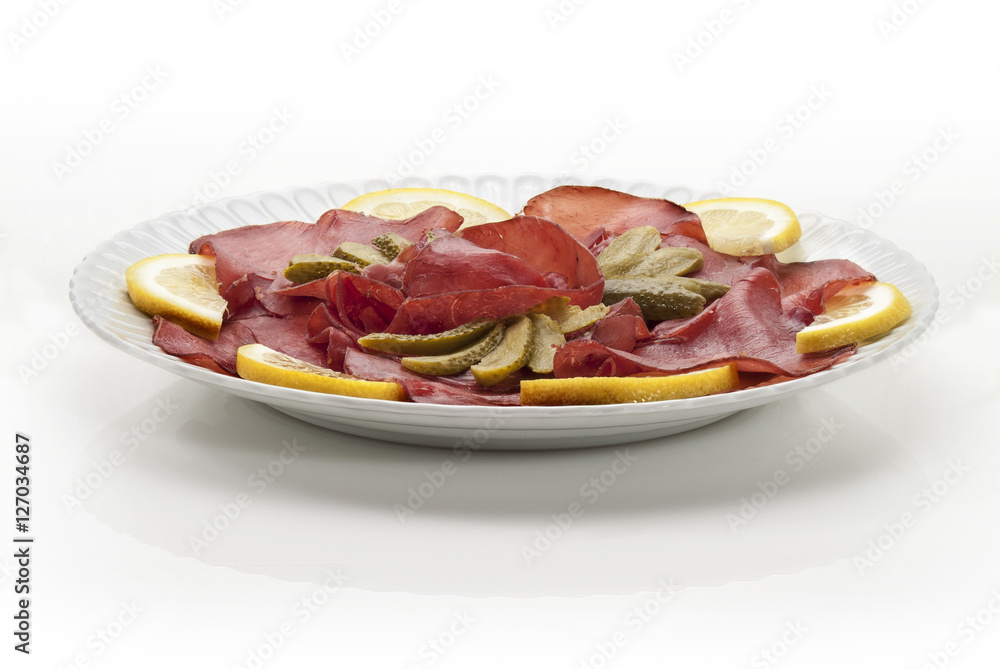 bresaola cetriolini e limone in piatto primo piano bresaola cetriolini e limone in piatto primo piano