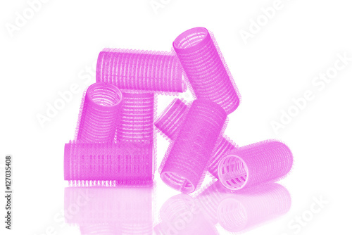 Fuchsia hair curlers isolated on white background with nice reflection