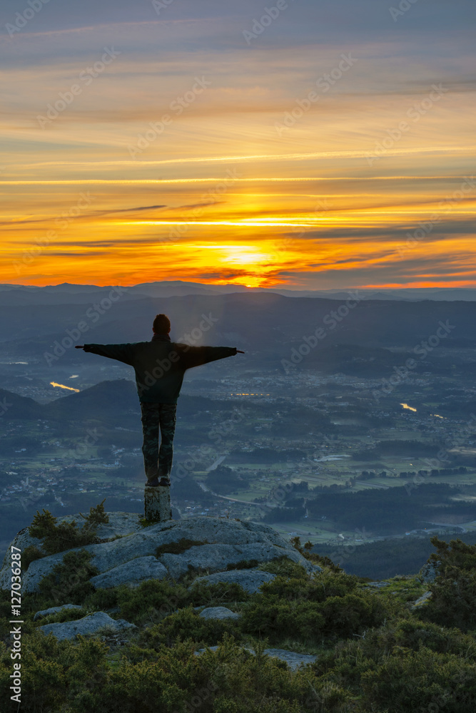 man on the top of the mountain at sunrise