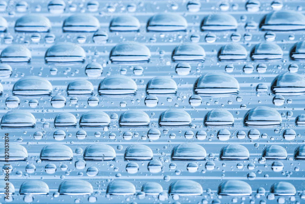 Fototapeta premium Blue water drops of on treat water-repellent surface in macro lens shot small-DOF for screen wallpapers