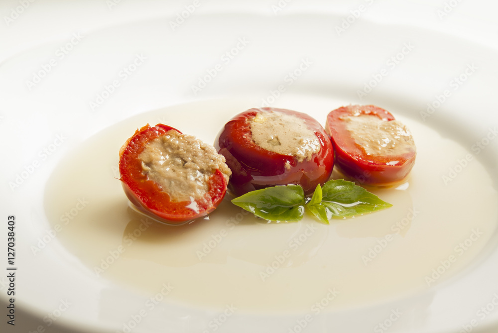 pomodorini farciti al tonno su piatto con olio e basilico pomodorini farciti al tonno su piatto con olio e basilico