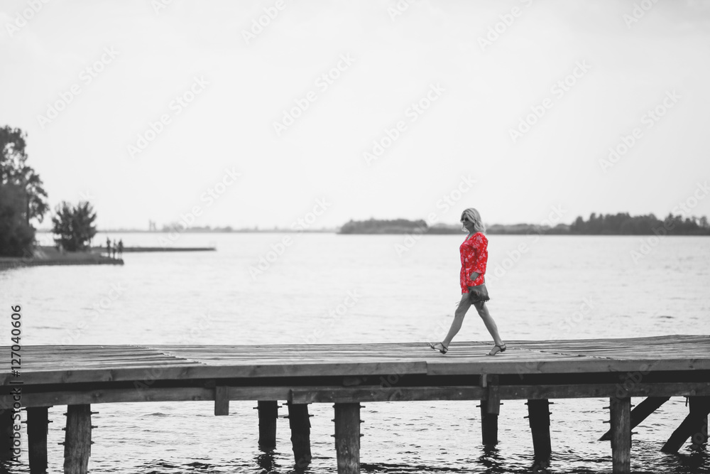 Woman in red jumpsuit at lake