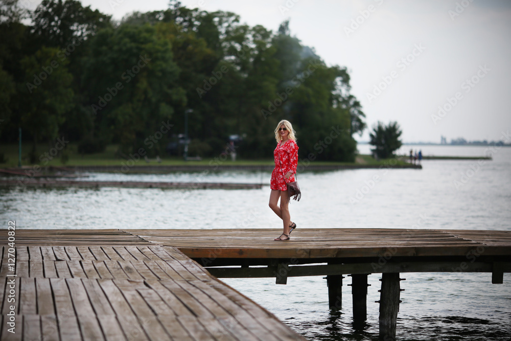 Woman in red jumpsuit at lake