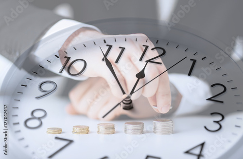 clock over businessman counting euro coins photo