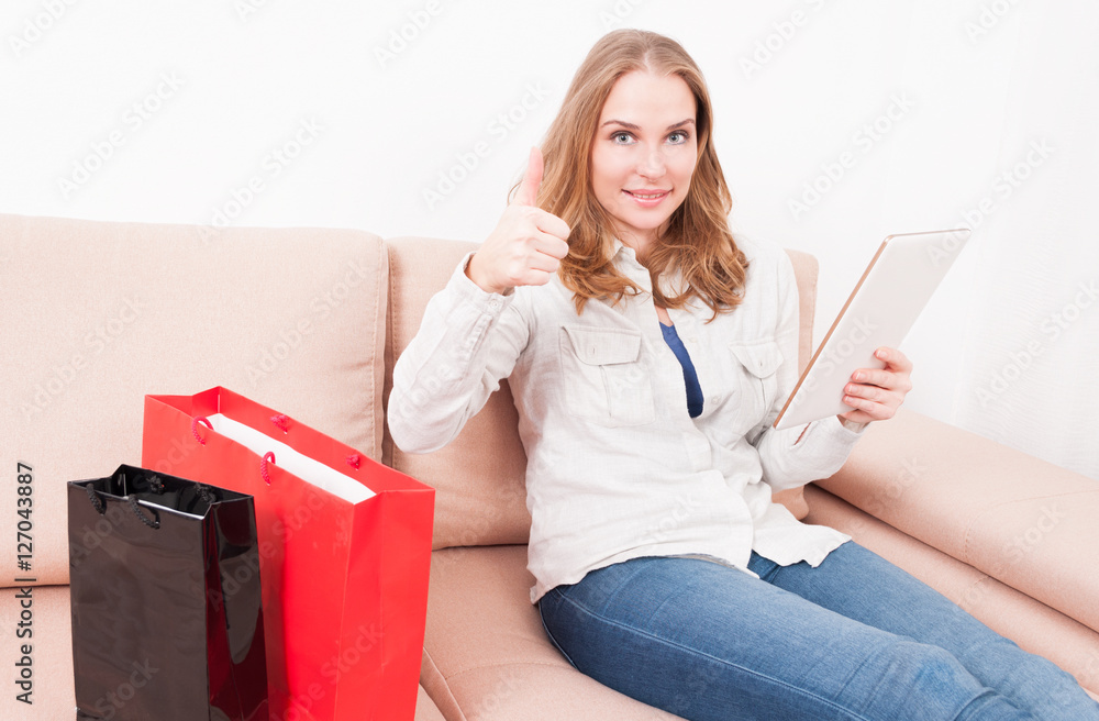 Lady laying on chouch holding tablet showing like Lady laying on chouch holding tablet showing like