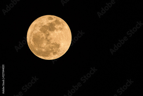 Full moon over dark black sky at night.
