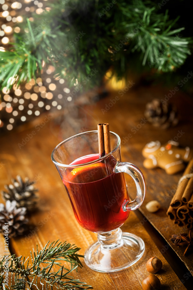 Winter holiday hot alcohol drink. Mulled wine with fruits and spices by Christmas tree. Winter holiday hot alcohol drink. Mulled wine with fruits and spices by Christmas tree.
