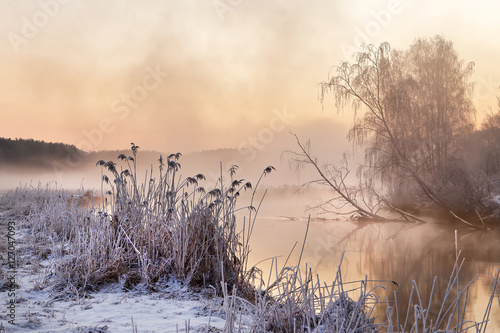 Winter misty morning on the river. Rural foggy and frosty scene.