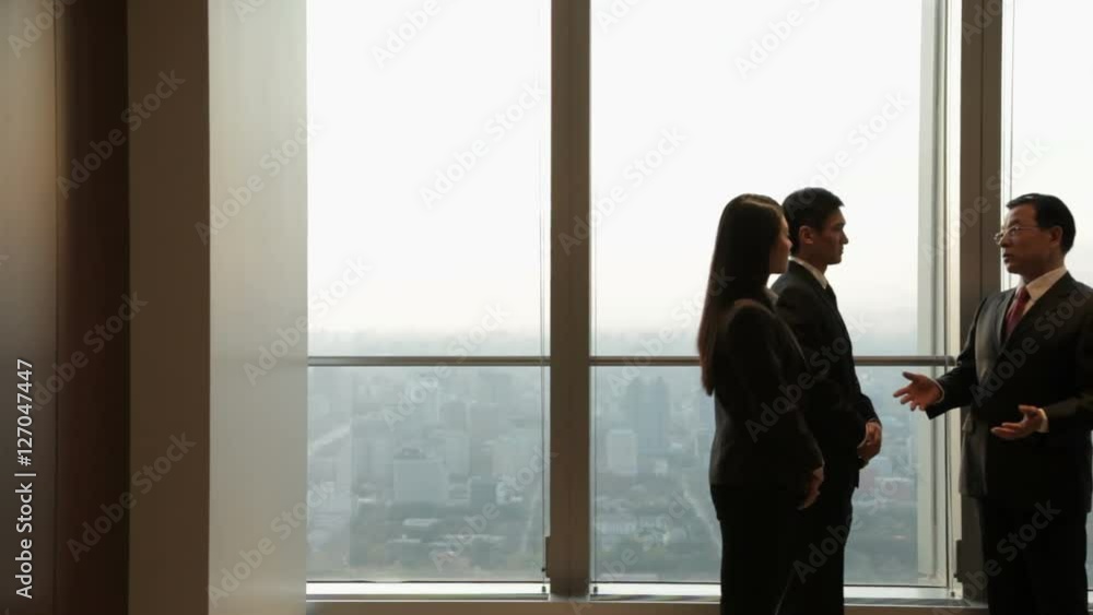 DS MS Business people shaking hands by window in office / China DS MS Business people shaking hands by window in office / China