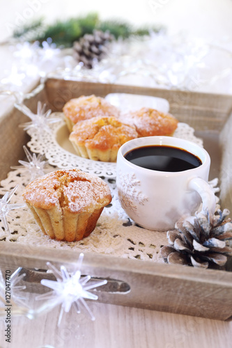 Christmas coffee break: muffins, cup of coffee and illuminated g