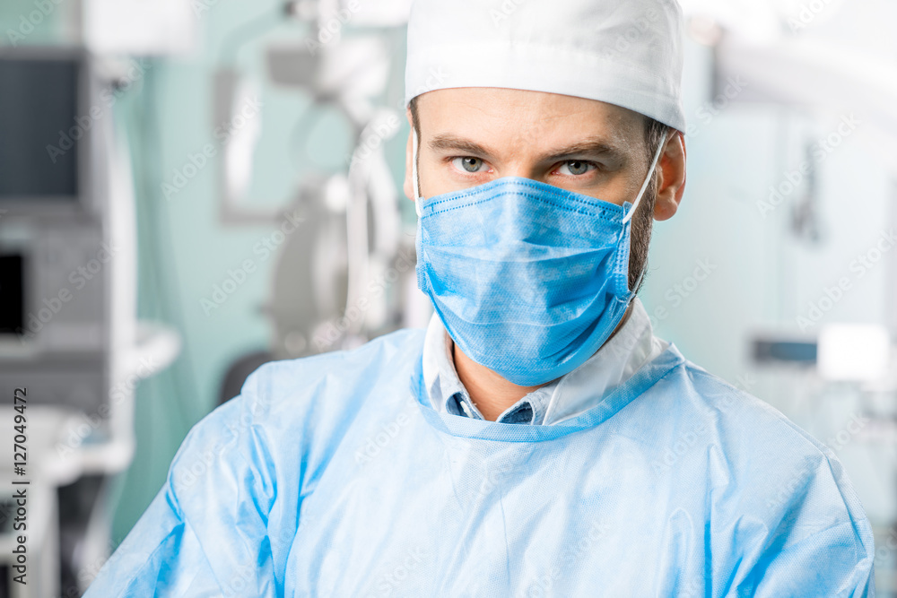 Portrait of surgeon in operating room with surgical microscope on the background Portrait of surgeon in operating room with surgical microscope on the background