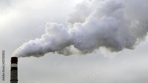 industrial chimneys emits toxic pollutants into the sky polluting the environment. photo