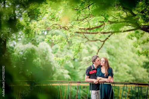 Dating. Young woman and man walking, couple in love relaxing in blossoming trees park at sunny spring day