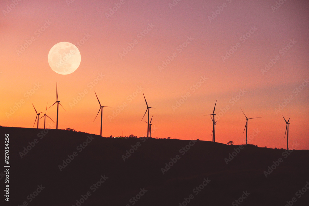 Obraz premium Landscape of turbine electric on hill with silhouette sky and full moon