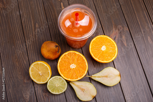 orange detox coctail with half orange lemon pear and lime lies o