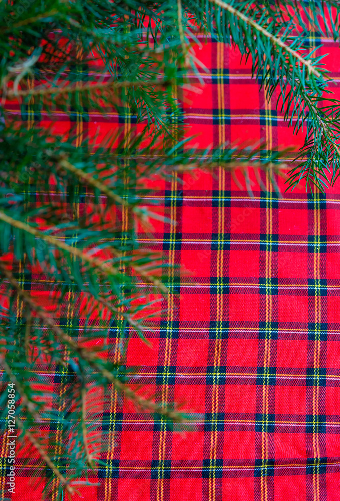 Christmas background with Christmas tree branch on a red tablecloth Christmas background with Christmas tree branch on a red tablecloth