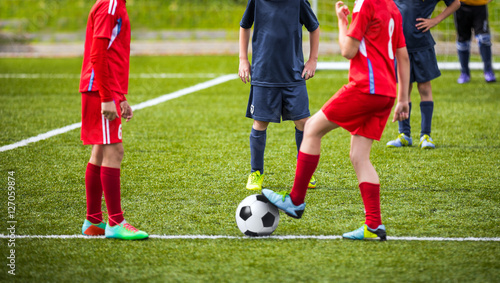 Young boys children in uniforms playing youth soccer football game tournament. Horizontal sport background